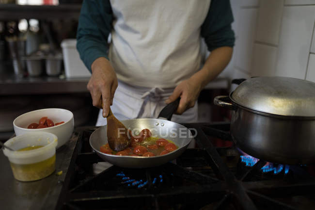Средняя секция пекаря мужского пола готовит еду в пекарне — стоковое фото