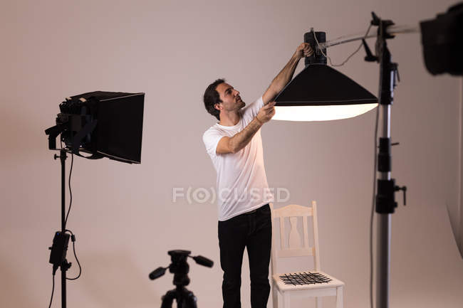 Männlicher Fotograf justiert Blitzlichter im Fotostudio — Stockfoto
