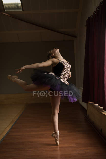 Грациозная балерина практикует арабескскую балетную позицию в студии — стоковое фото