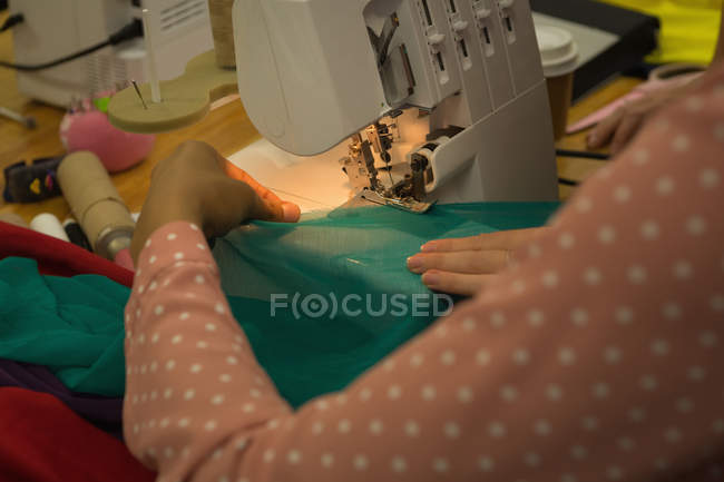 Close-up de designer de moda usando máquina de costura no estúdio de moda — Fotografia de Stock