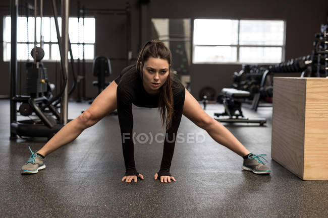Fit woman doing stretching exercise in fitness studio — Stock Photo