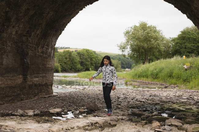 Giovane ragazza a piedi vicino al fiume — Foto stock