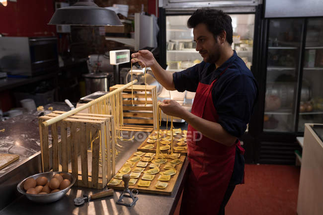Baker preparing handmade pasta in bakery — Stock Photo