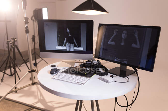 Female model posing on computer screen in photo studio — Stock Photo