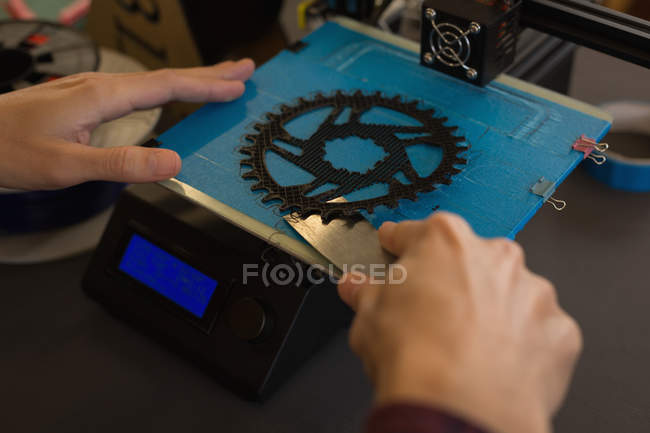 Primer plano del mecánico sacando anillo de cadena de la máquina de troquel en el taller - foto de stock