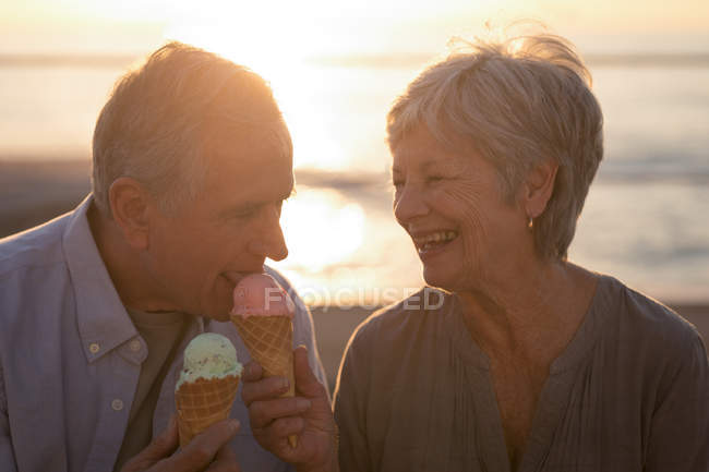 Primer plano de pareja mayor tomando helado en el paseo marítimo - foto de stock