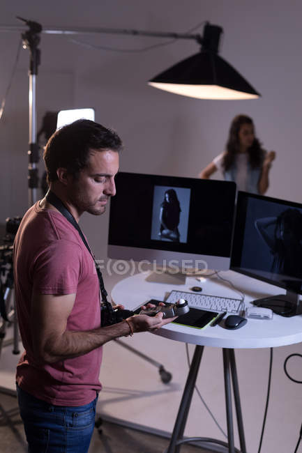 Fotógrafo masculino segurando gravador de voz no estúdio de fotografia — Fotografia de Stock