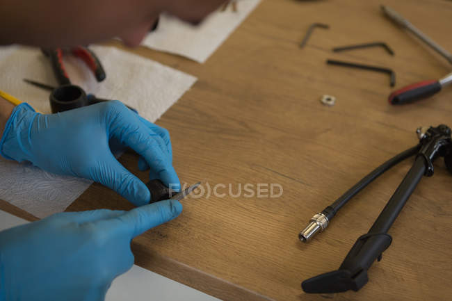 Man filing bicycle parts on counter in workshop — Stock Photo