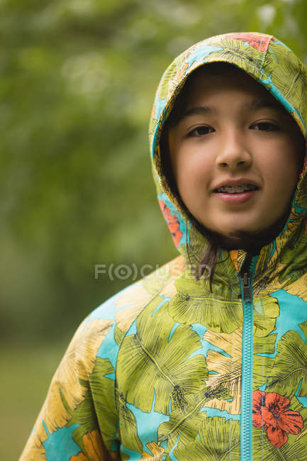 Nahaufnahme eines Mädchens im Regenmantel, das in die Kamera blickt — Stockfoto
