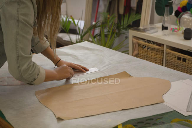 Модный дизайнер, измеряющий на ткани в студии моды — стоковое фото