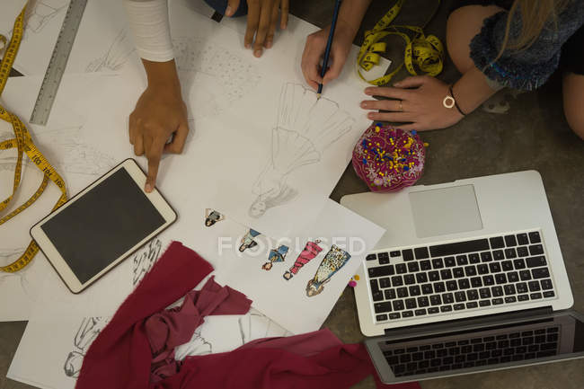 Diseñadores de moda dibujando un boceto usando tableta digital en estudio de moda - foto de stock