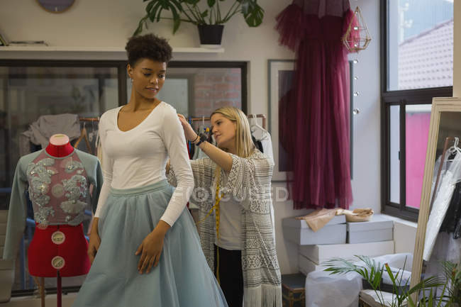 Designer de moda fazendo a medição do cliente no estúdio de moda — Fotografia de Stock