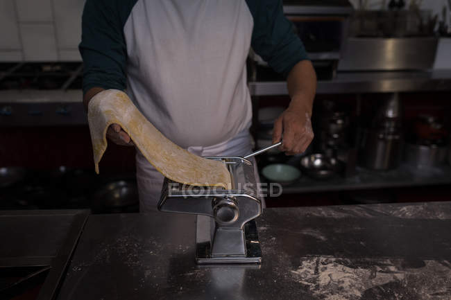 Boulanger utilisant la machine pour préparer les pâtes dans la boulangerie — Photo de stock