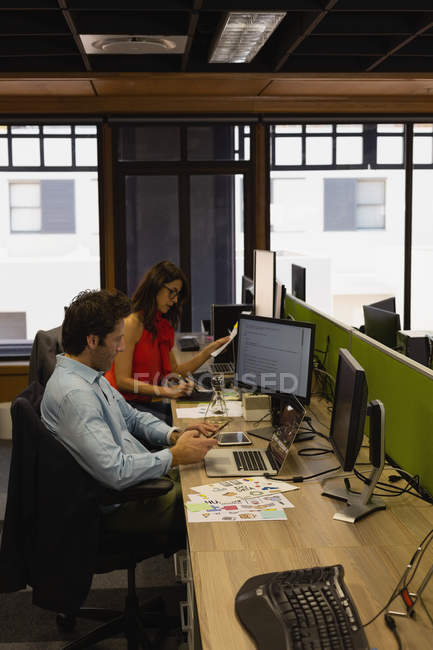 Businessman using mobile phone at office — Stock Photo