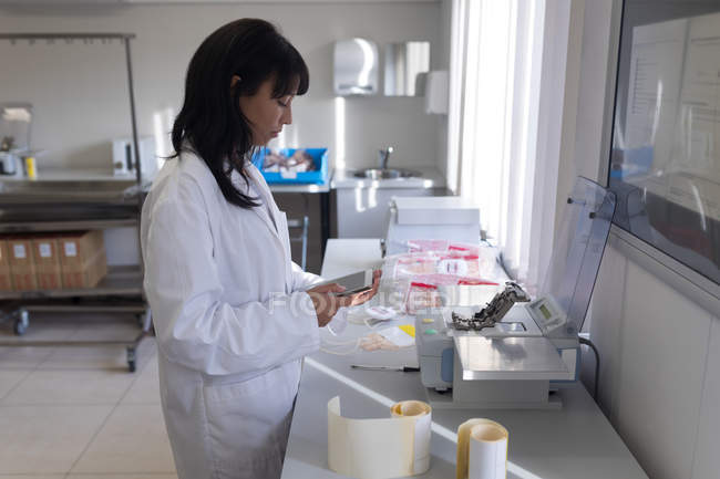 Técnico de laboratório usando comprimido digital no banco de sangue — Fotografia de Stock