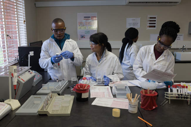 Técnicos de laboratório interagindo uns com os outros no banco de sangue — Fotografia de Stock