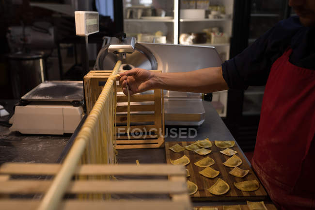 Mittelteil des Bäckers bereitet handgemachte Pasta in Bäckerei zu — Stockfoto