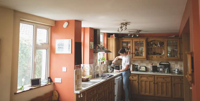 Hombre preparando café en la cocina en casa . - foto de stock