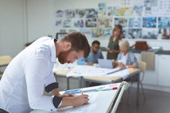 Executive working on drafting table in office — Stock Photo