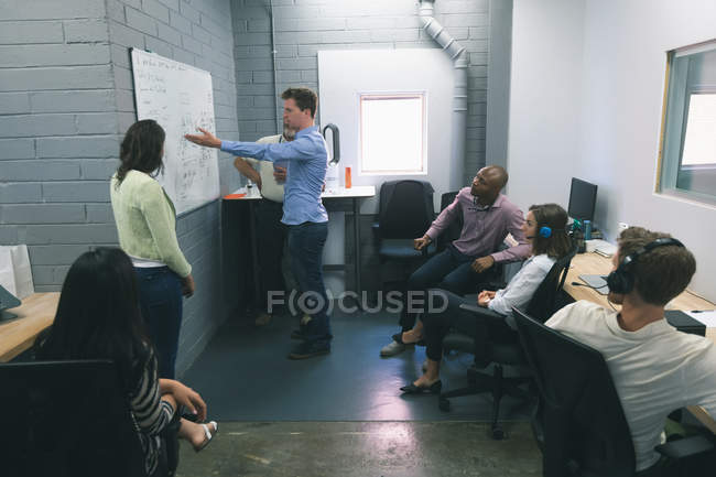 Geschäftsleute diskutieren über Whiteboard im Büro — Stockfoto