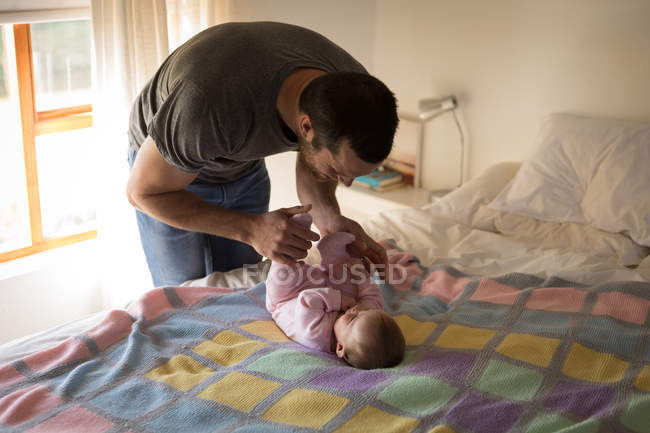 Père s'amuser avec bébé sur le lit à la maison — Photo de stock