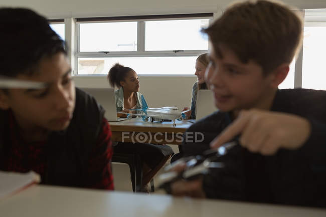 Students discussing together over model aeroplane in training institute — Stock Photo