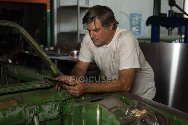 Meccanico maschio con tablet digitale in garage — Foto stock