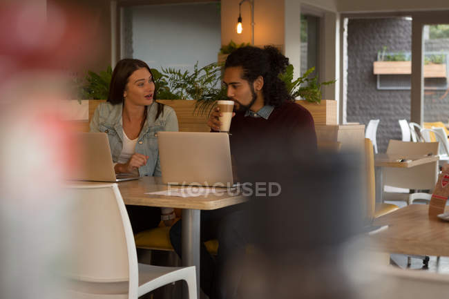 Молодая пара разговаривает друг с другом в кафе — стоковое фото