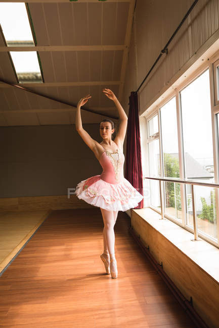 Beautiful ballerina practicing ballet dance in dance studio — Stock Photo