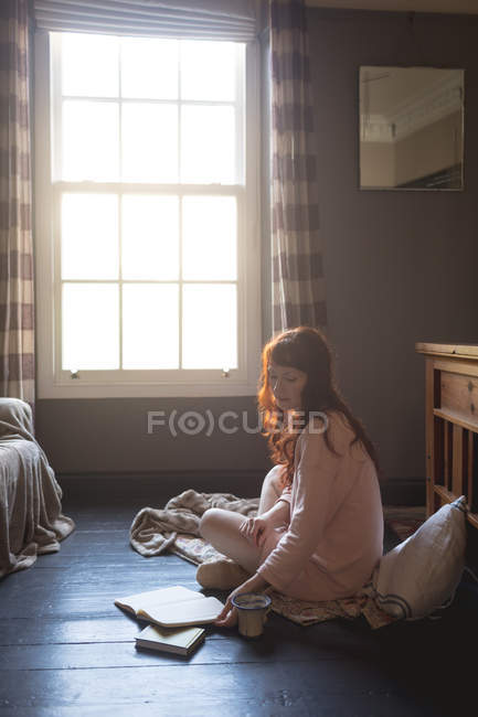 Femme lecture livre à la maison — Photo de stock