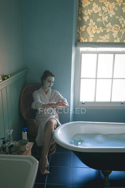 Mulher aplicando creme no banheiro em casa — Fotografia de Stock