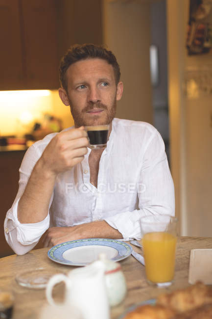 Uomo premuroso che prende un caffè a casa — Foto stock