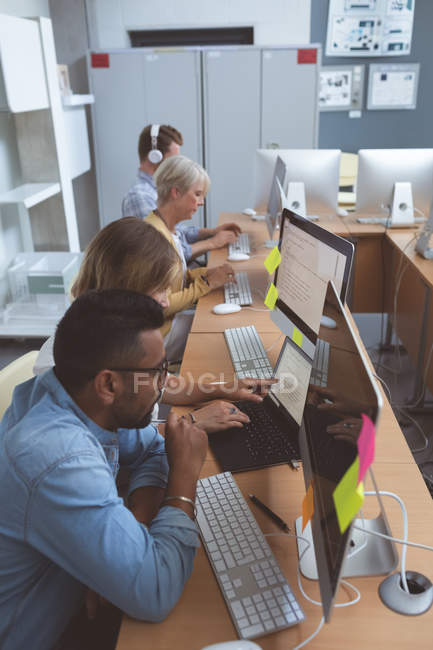 Ejecutivos atentos que trabajan en el escritorio en la oficina - foto de stock