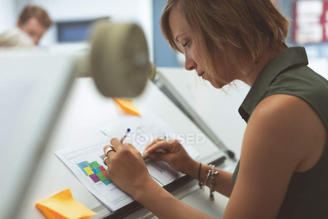Exécutif féminin travaillant sur la table de rédaction en fonction — Photo de stock