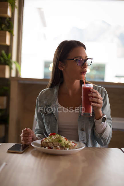 Bella donna che ha cibo nel caffè — Foto stock