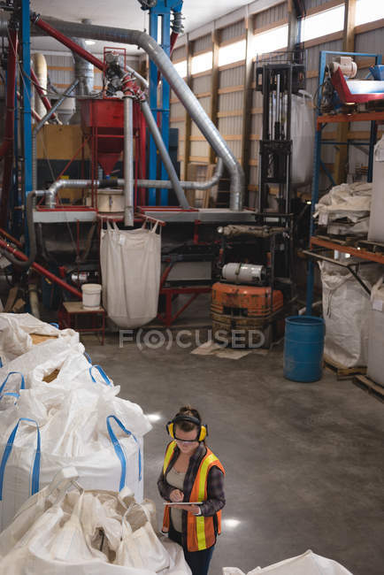 Female worker using digital tablet at warehouse — Stock Photo