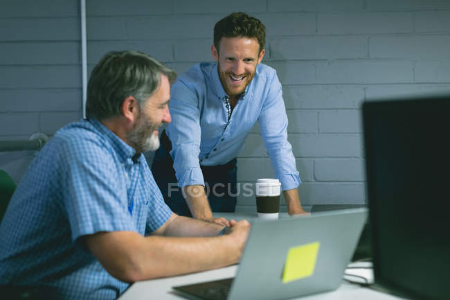 Des collègues d'affaires discutent sur ordinateur portable au bureau — Photo de stock