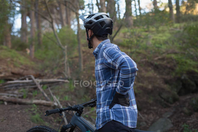 Man with bicycle standing with hand on hip on lane — Stock Photo