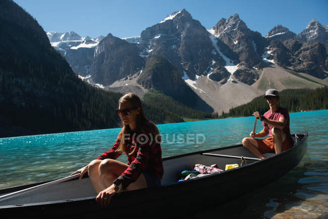 Couple naviguant en rivière par une journée ensoleillée — Photo de stock