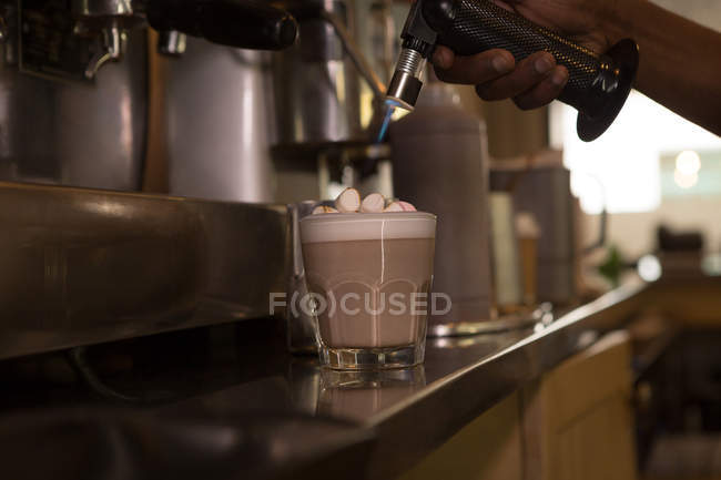 Primer plano del camarero preparando café en el mostrador en la cafetería - foto de stock