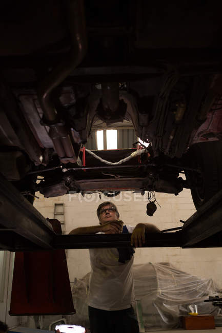 Male mechanic servicing a car in garage — Stock Photo
