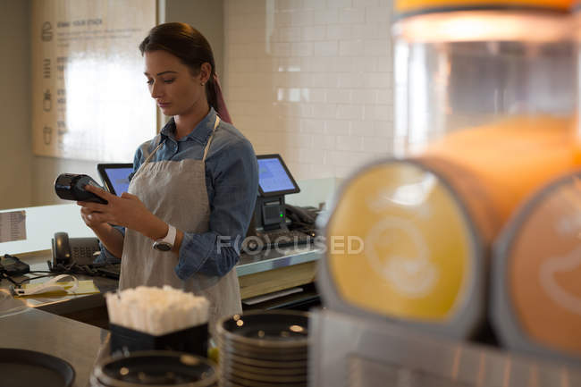 Camarera usando la máquina NFC en la cafetería - foto de stock
