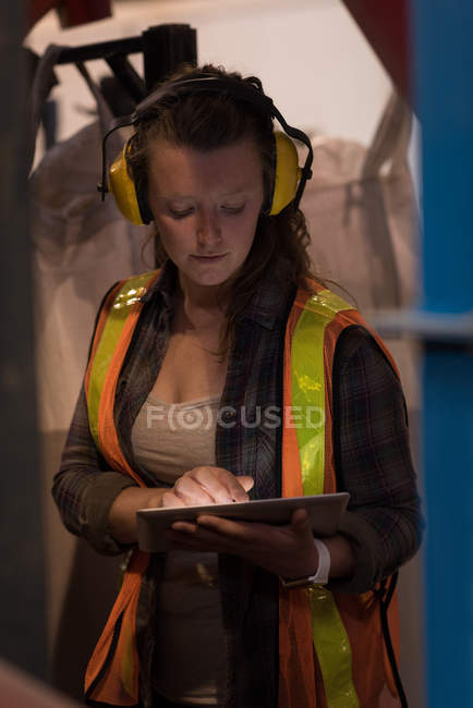 Красивая работница с помощью цифрового планшета на складе — стоковое фото