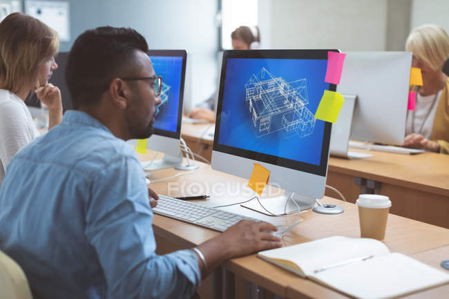 Aufmerksame Führungskraft arbeitet am Desktop-PC am Schreibtisch im Büro — Stockfoto