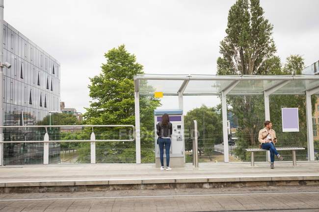 Pendler nutzen Fahrkartenautomaten am Bahnhof — Stockfoto