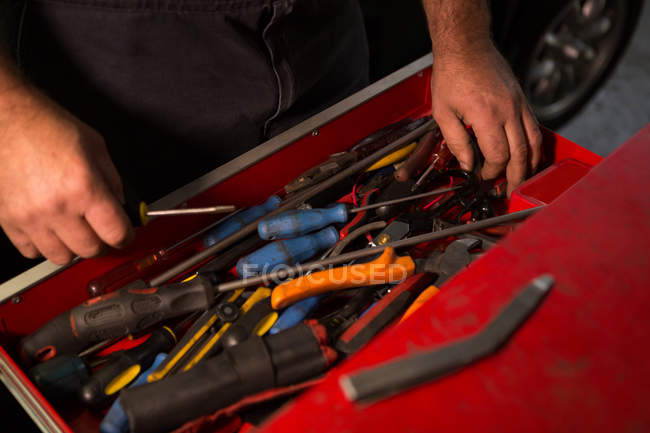 Meccanico maschio rimozione utensili dal cassetto in garage — Foto stock