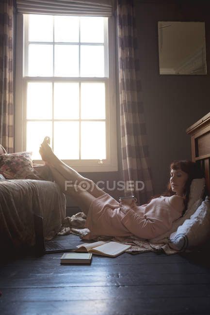 Mujer relajándose con los pies en la sala de estar en casa - foto de stock