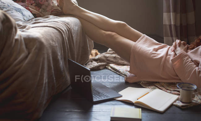 Femme relaxante avec les pieds dans le salon à la maison — Photo de stock