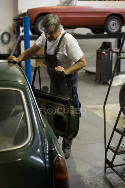 Meccanico maschio che controlla un'auto in garage — Foto stock