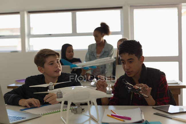 Estudiantes discutiendo juntos sobre avión modelo en instituto de entrenamiento - foto de stock